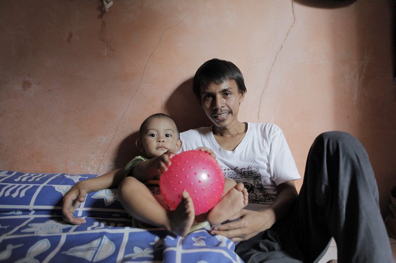 32 year old Hamdani with his two year old son Restu. Hamdani made Adidas sports shoes until 2005 when he was unfairly dismissed for participating in a strike for better wages. Photo: Tim Herbert/OxfamAUS