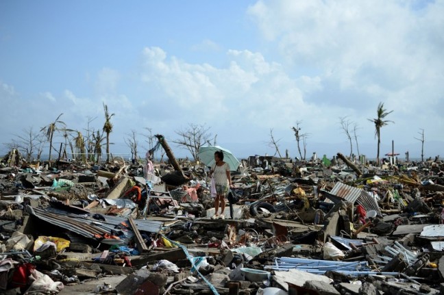 A surivor walks among the debris of houses destroyed by Super Typhoon Haiyan in Tacloban in the eastern Philippine island of Leyte on November 11, 2013. Photo: AFP PHOTO/NOEL CELIS