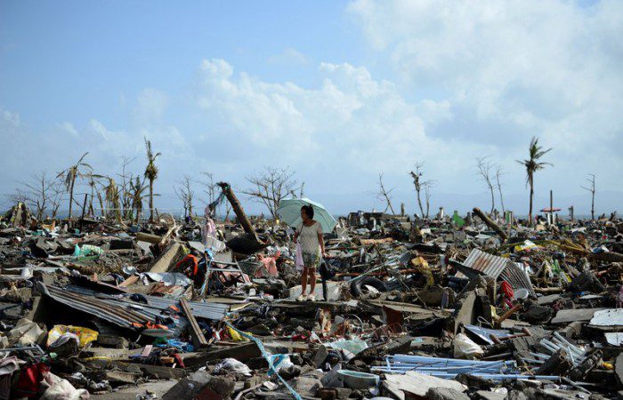 A survivor walks among the debris of houses destroyed by Super Typhoon Haiyan in Tacloban in the eastern Philippine island of Leyte on November 11, 2013.