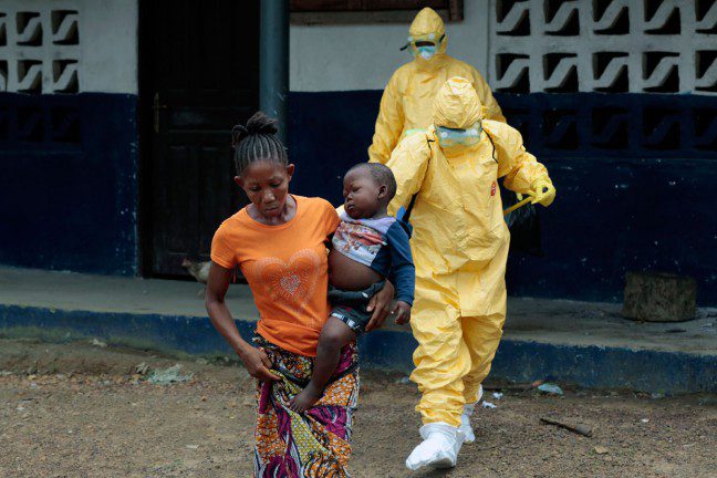 Marie carries her son Nathaniel, aged two, to an ambulance after showing signs of Ebola infection, Liberia. Photo: AP Photo/Jerome Delay