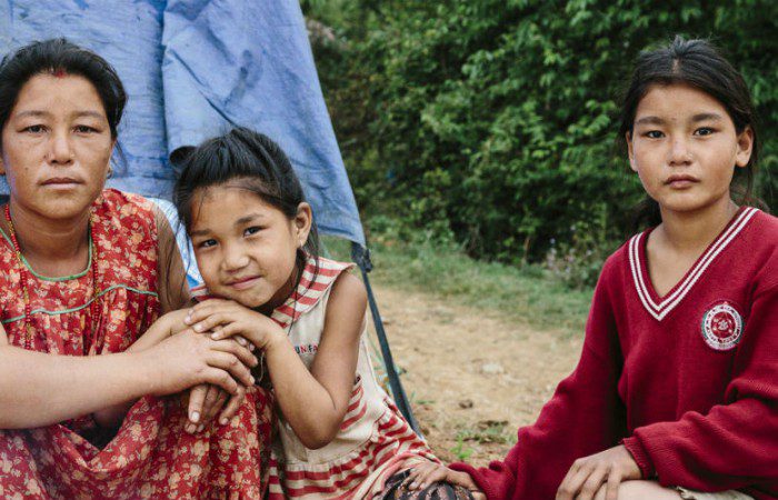 Kavita stands with her two daughters outside their temporary shelter after the Nepal earthquake struck on 25 April 2015.