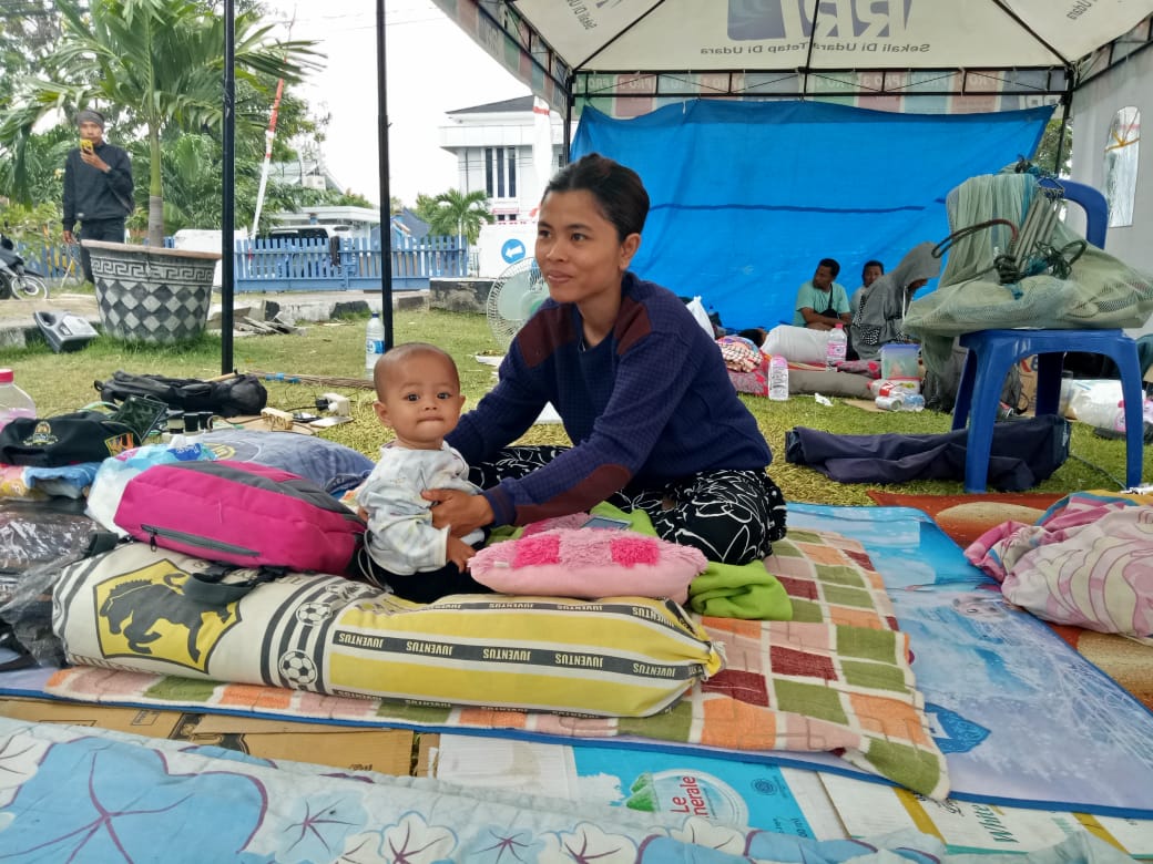 28-year-old Iren takes care of her 7-month-old baby. Iren, a mother of two, has spent six nights in this tent at an IDP compound. Iren's house collapsed during the earthquake in Indonesia. Donate today.
