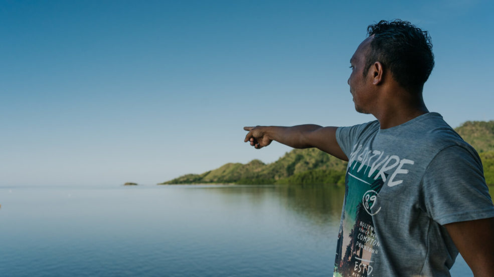 Man pointing at mangrove plantation