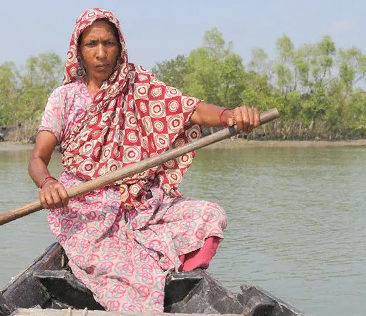 A woman rows a boat over a swelling river